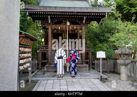 Japanese Couple with Kimono in front of Shrine Praying Stock Photo