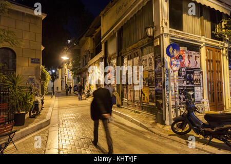 ATHENS, GREECE - NOVEMBER 3, 2017: building corner in Psyri district of Athens' city center, left to decay and ruin, with people walking in the dark   Stock Photo