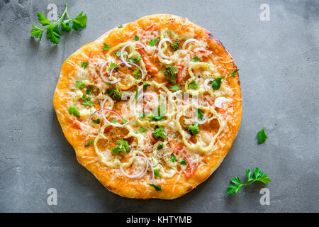 Vegetarian Pizza on rustic concrete background. Italian Pizza with Vegetables and Cheese close up. Stock Photo