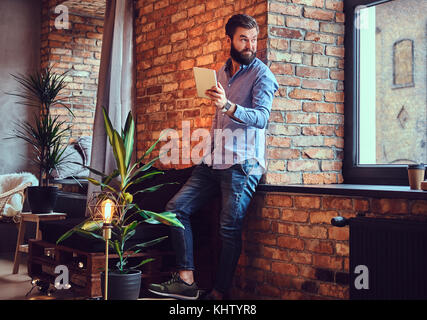 A man using tablet PC in a room. Stock Photo