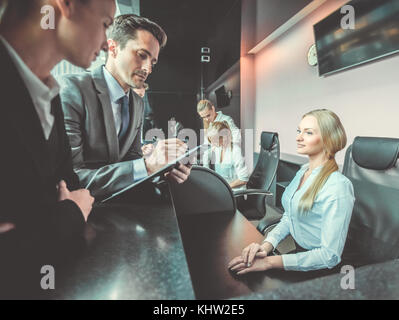 Business people filling forms at reception front desk Stock Photo