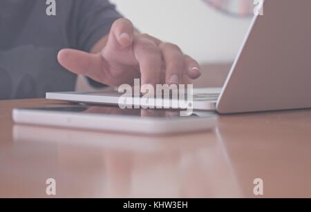 Teenager using laptop computer and mobile phone at home Stock Photo
