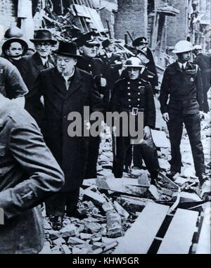 Photograph of Sir Winston Churchill walking amongst the rubble of homes as a result of an air raid on London. Sir Winston Leonard Spencer-Churchill (1874-1965) a British politician and Prime Minister of the United Kingdom. Dated 20th Century Stock Photo
