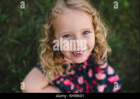 Overhead portrait of blond haired girl on grass Stock Photo