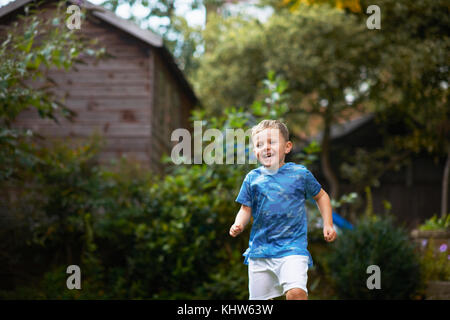 Boy running in garden Stock Photo