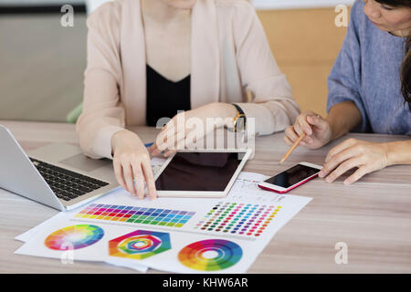 Colleagues working with colour charts and graphs Stock Photo