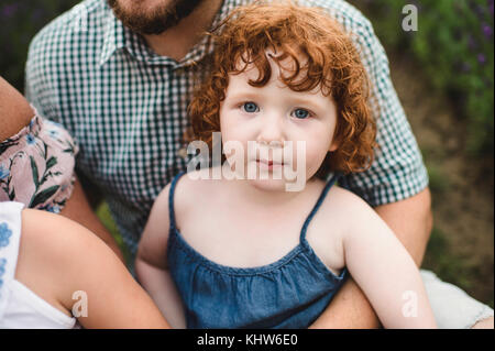 Toddler sitting on father's lap Stock Photo