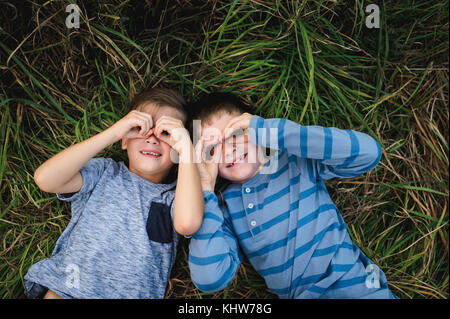 Brothers lying on grass together Stock Photo