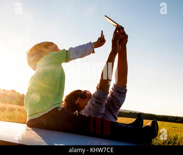 Father and son in rural setting, taking selfie, using smartphone, Sverdlovsk, Russia, Europe Stock Photo