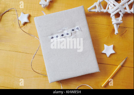 Notebook on a wooden background with a decor of white stars Flat lay, top view photo mockup Stock Photo
