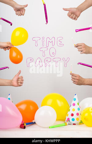 equipment, party, fiest concept. in the center there is words created of funny font with pink line, they say that it is time for party, and lots of balloons and whistles are lying around Stock Photo