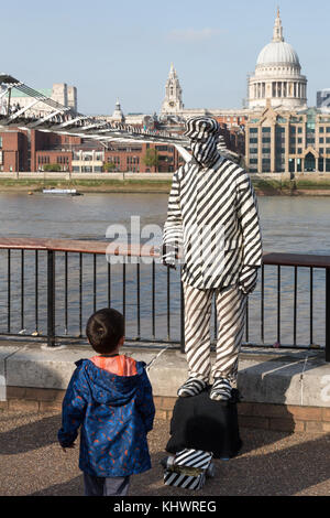 Human Statue in black and white stripes by Millennium Bridge, London, UK Stock Photo