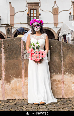 A young woman dressed in La Calavera Catrina bride costume during the Day of the Dead or Día de Muertos festival October 31, 2017 in Patzcuaro, Michoacan, Mexico. The festival has been celebrated since the Aztec empire celebrates ancestors and deceased loved ones. Stock Photo