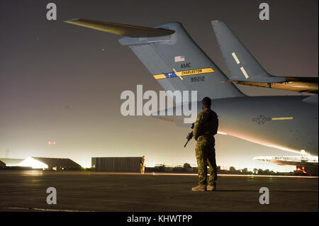 A U.S. Air Force Security Forces Phoenix Raven Team Member assigned to the 816th Expeditionary Airlift Squadron protects a C-17 Globemaster III while conducting combat airlift operations for U.S. coalition forces in Iraq and Syria in support of Operation Inherent Resolve, Nov. 11, 2017. The Phoenix Raven program ensures close-in security for aircraft transiting airfields where security is unknown or additional security is needed. Stock Photo