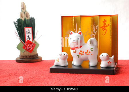 Japanese new year dog object on red white paper background Note: Japanese words of this photography mean "spring welcoming" and "long life" Stock Photo