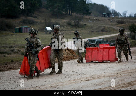 Soldiers from Company C, 2nd Battalion, 70th Armor Regiment, 2nd Armored Brigade Combat Team, 1st Infantry Division from Fort Riley, Kansas move road barricades during the Allied Spirit VII training exercise in Grafenwoehr, Germany Nov. 17, 2017. The U.S. Army, along with its allies and partners, continues to forge a dynamic presence with a powerful land network that simultaneously deters aggression and assures the security of the region. Approximately 3,700 service members from 13 nations gathered in 7th Army Training Command’s Hohenfels Training Area in southeastern Germany to participate in Stock Photo