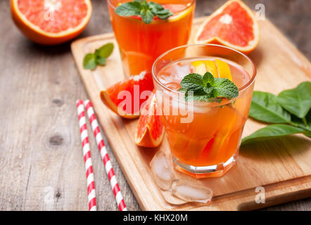 grapefruit cocktail with ice, mint in glass glasses on a wooden background Stock Photo