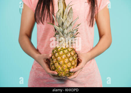 Female hand holding ripe pineapple Stock Photo