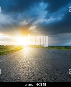 dark low clouds over asphalt road on sunset Stock Photo - Alamy