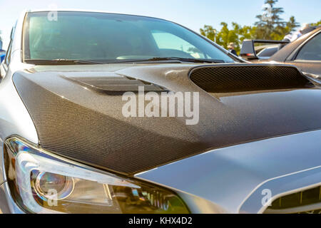 Carbon fiber hood on a white car. Custom cars in Southern California summer 2017 Stock Photo