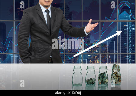 Businessman with Step of coins bottle in office conference meeting room on photo blurred cityscape, Business investment growth concept Stock Photo