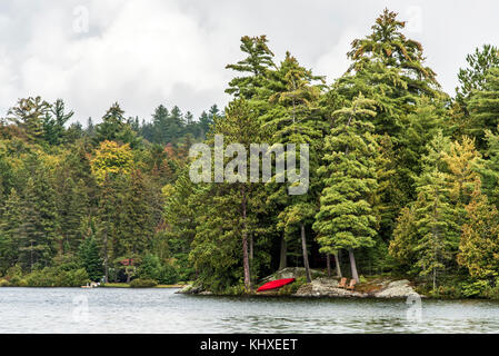 red relax chair in Canada Ontario Lake of two rivers natural wild landscape near the water in the Algonquin National Park Stock Photo