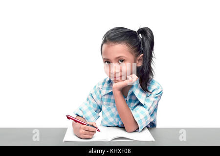 Cute asian girl writing on the book with pen isolated over white background Stock Photo