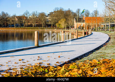 Vaxjo, Sweden - November 13, 2017: Documentary of everyday life and environment. The frosty boardwalk at Vaxjo lake on a sunny fall morning. Swedish f Stock Photo