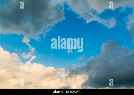 Cloudscape with contrasting clouds and a clear gap of the blue sky between them Stock Photo