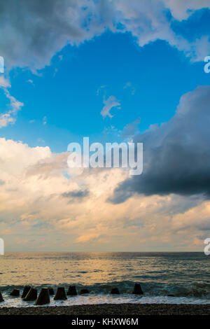 Seascape with contrasting clouds over the sea and a clear gap of the blue sky between them Stock Photo