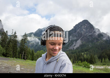 Portrait of teenage boy in rural setting, wearing headphones Stock Photo