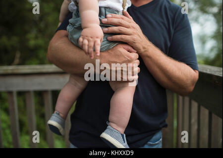 Mid section of man carrying toddler son on balcony Stock Photo