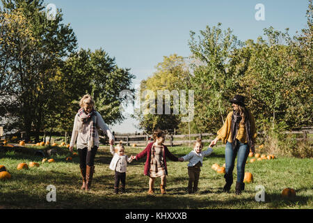 Women and children holding hands in field of pumpkins, Oshawa, Canada, North America Stock Photo