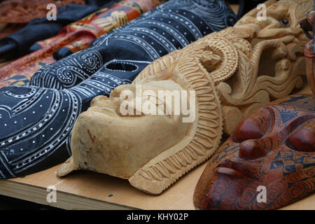 Close up Indian and African handmade ethnic wooden carved masks on retail market display, low angle view Stock Photo