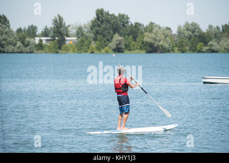 man enjoying a ride on the lake with paddleboard Stock Photo