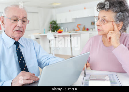 elderly couple using laptop at home Stock Photo