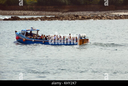 The Pleasure Boat (Guiding Star) Full of Tourists Leaving Hugh Town Harbour on the Island of St Marys in the Isles of Scilly, United Kingdom. Stock Photo