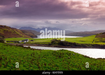 The summits of the Black Cuillin hills emerge from the clouds, viewed from above Gesto Bay on the Isle of Skye. Highland, Scotland, UK Stock Photo