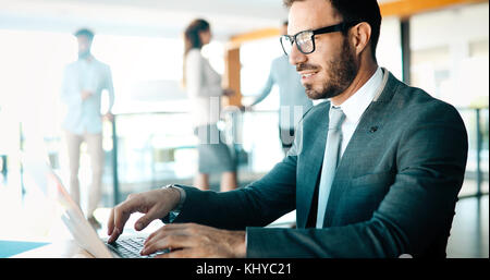 Professional handsome businessman using laptop at workplace Stock Photo