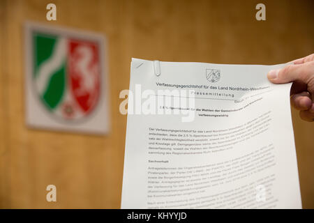 Muenster, Germany. 21st Nov, 2017. ILLUSTRATION - A person holds the press statement with the decision of the constitutional court in Muenster, Germany, 21 November 2017. The Constitutional Tribunal North Rhine-Westphalia decided that the 2.5 percentage restrictive clause at local elections is unlawful. Several parties, among them the National Democratic Party of Germany (NPD) and The Left, brought an action against the clause which was introduced in 2016. Credit: Friso Gentsch/dpa/Alamy Live News Stock Photo