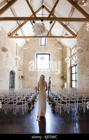 Groom waiting at church altar as bride walks down the aisle Stock Photo
