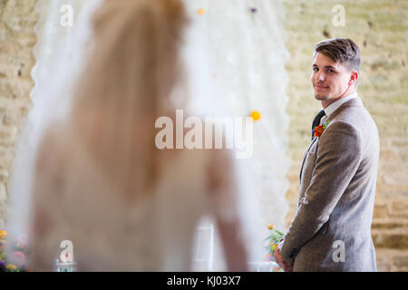Groom waiting at church altar as bride walks down the aisle Stock Photo