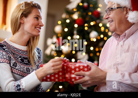 Woman having gift surprise from parent for Christmas Stock Photo