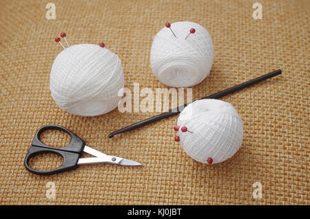 Objects for sewing. Scissors and pins. Hanks thread on mat. Pins Stock Photo