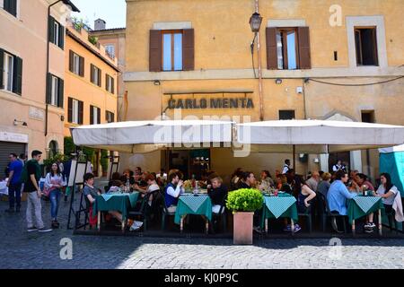 ROME, ITALY - APRIL 12, 2017: People eating traditional italian food in outdoor restaurant Carlo Menta in Trastevere district in Rome, Italy on April. Stock Photo