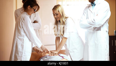 Group of medical students practicing reanimation task on model Stock Photo
