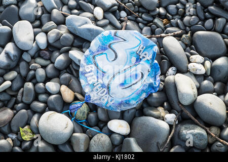 30th,Birthday,balloon,deflated,pollute,beach,found,on,pebbles,Ynyslas Beach,near Borth,north,of,Aberystwyth,Ceredigion,Mid,West,Wales,UK,U.K.,Europe, Stock Photo