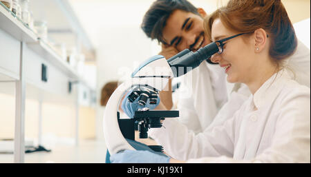 Group of scientists doing research looking through microscope Stock Photo