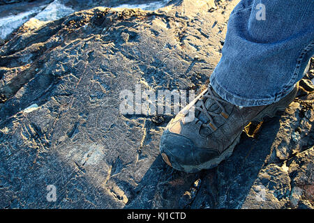 Closeup of a hiking boot on rocky ground. Stock Photo