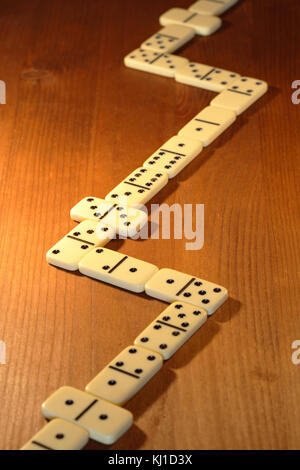 Long line made from dominoes on wooden background Stock Photo